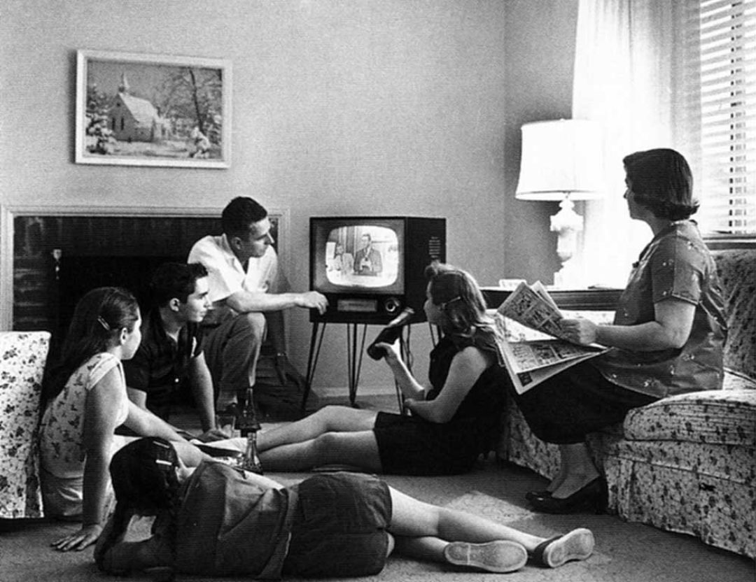 1950's family sitting around a retro TV
