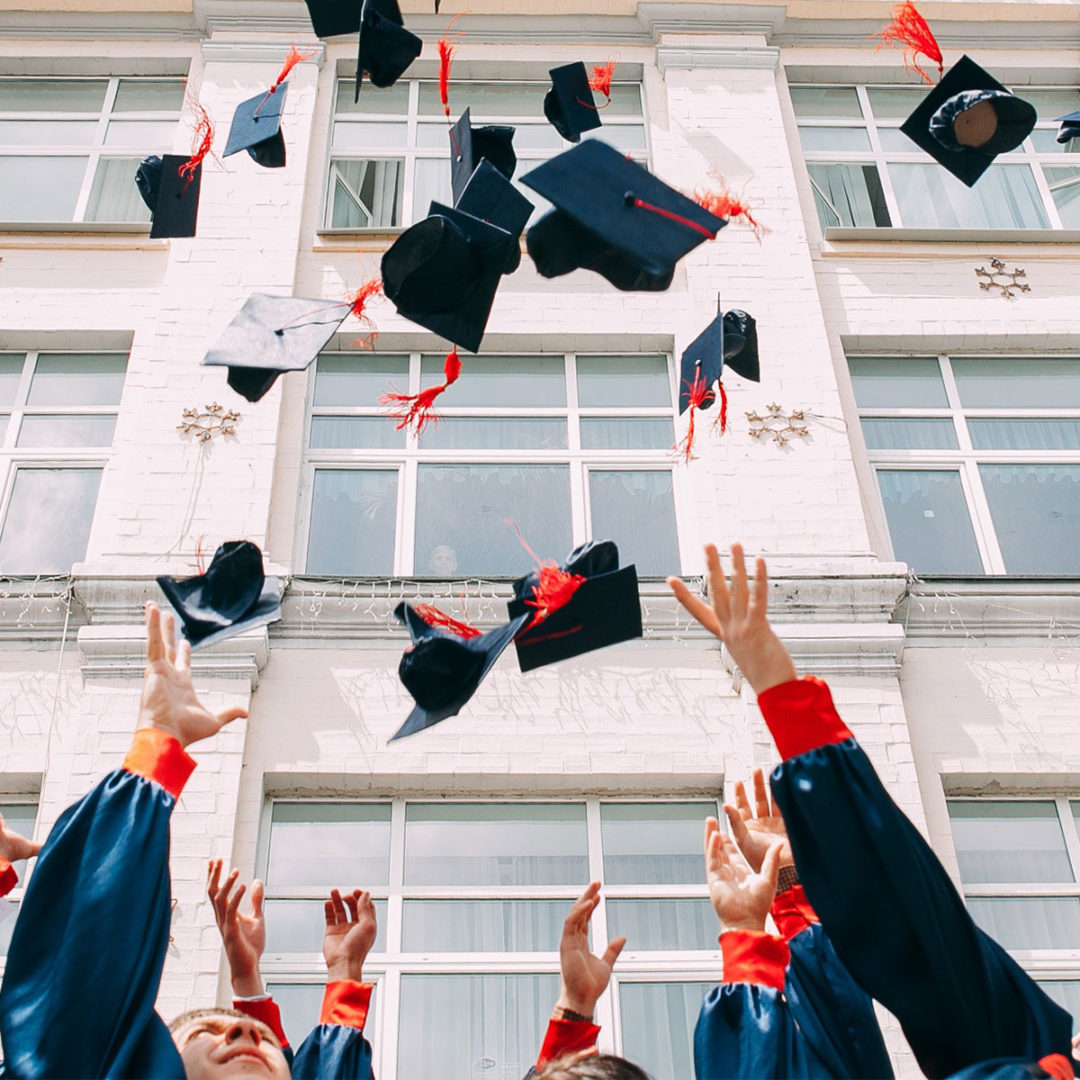 College graduates throwing caps into the air