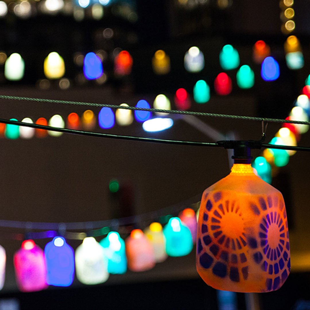 Lightbulbs hung through an urban environment