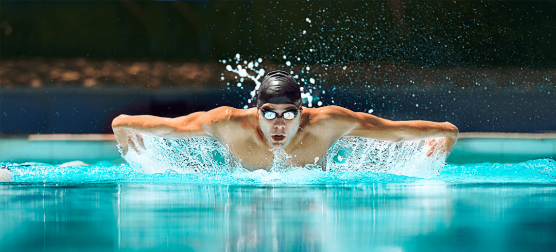 Man does butterfly stoke in swimming pool