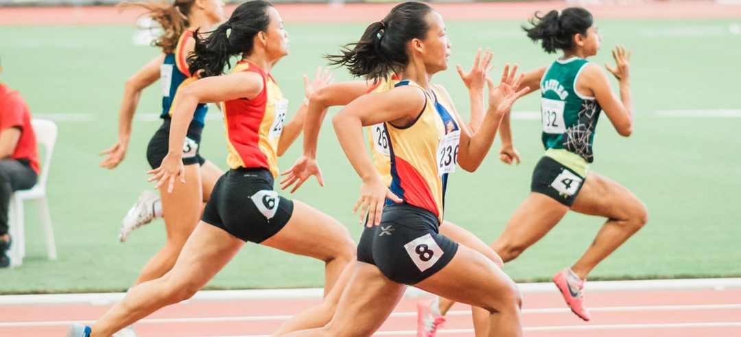Female sprinters running on a track