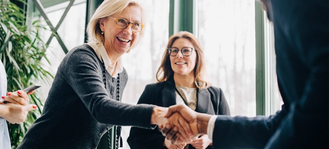 Woman shakes hand with man at a business meeting