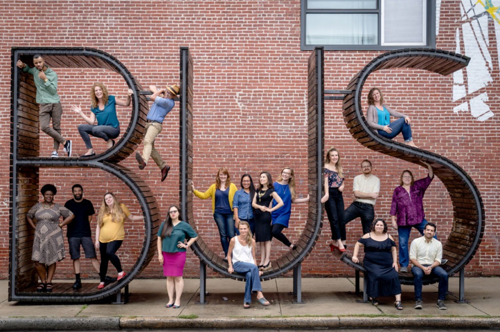 Creative alliance members posing in front of a monument.