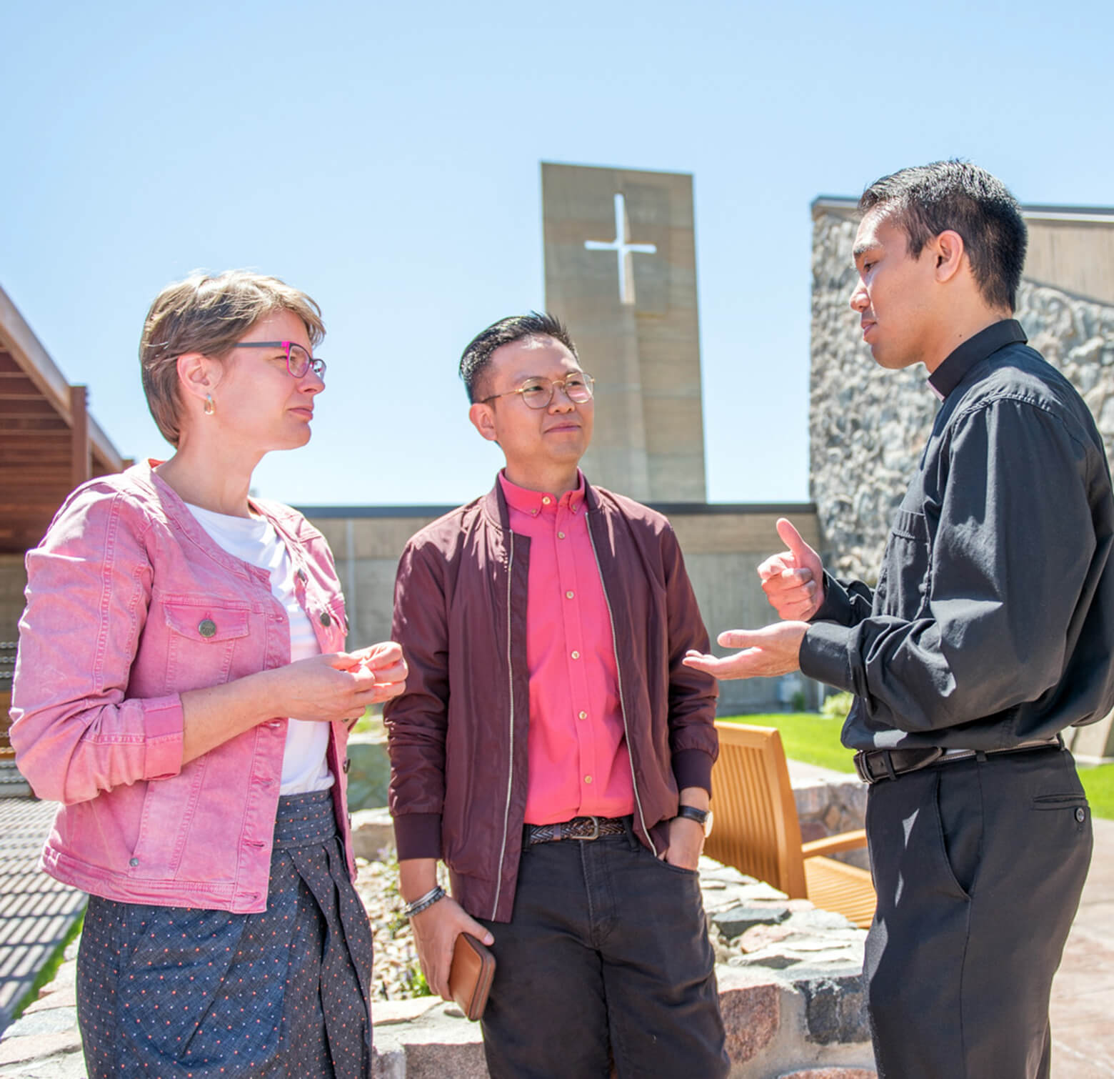 3 people talking outside of a church