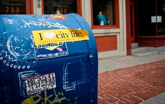 A Baltimore City mailbox with an "I Heart City Life" bumper sticker attached to it