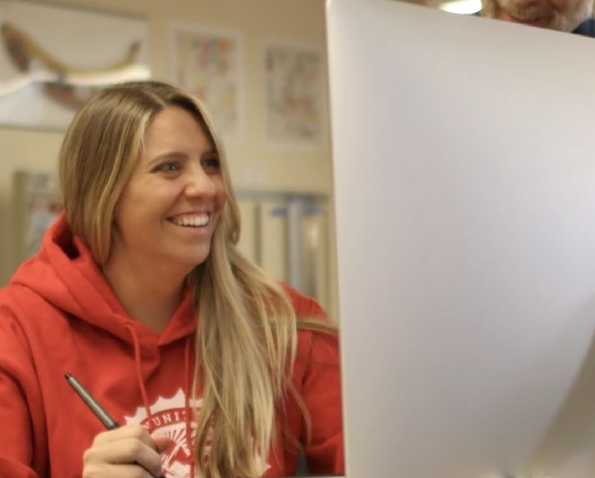 Woman smiling working on computer.