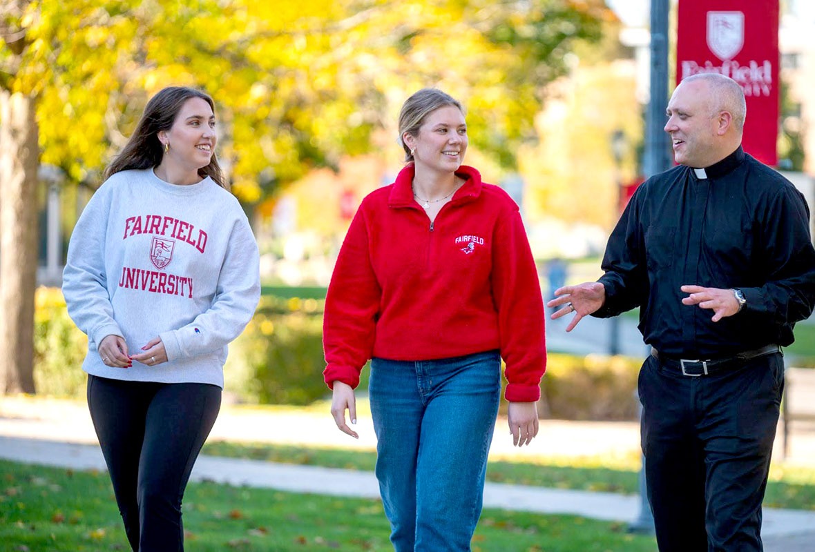 Fairfield students and professor talking on campus grounds.