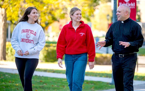 Fairfield students and professor talking on campus grounds.